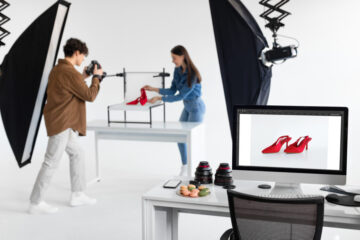 Male photographer and female art director taking photos of shoes, working in photostudio, focus on monitor with picture Male photographer and female art director taking photos of shoes, working in photostudio, focus on monitor with picture